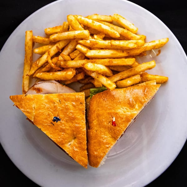 A Z Cafe & Bar panini sandwich, cut in half, served with a side of golden french fries.