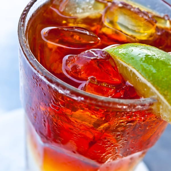 Close-up of a refreshing iced tea with a lime wedge, condensation on the glass.