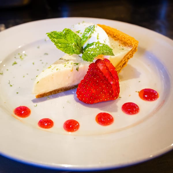 Slice of Z Cafe & Bar's key lime pie with whipped cream, mint, strawberries, and raspberry coulis.